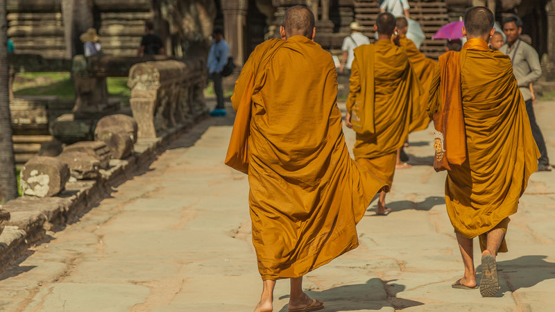 Three Cambodian monks walking along a path