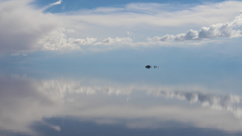Perfect reflections of the sky with a distant 4WD