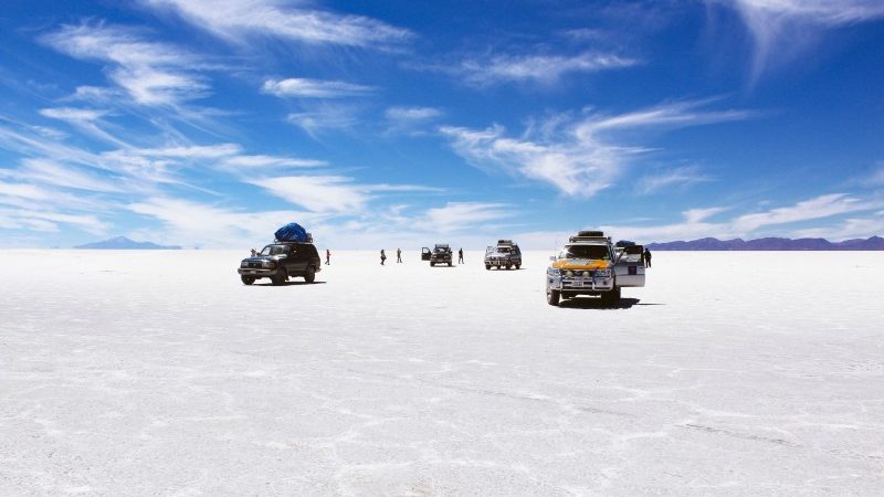 Four 4WDs park on the salt flats of Uyuni in Bolivia