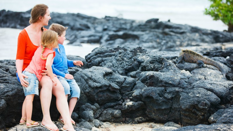 Family looking at a marine iguana in the Galapagos
