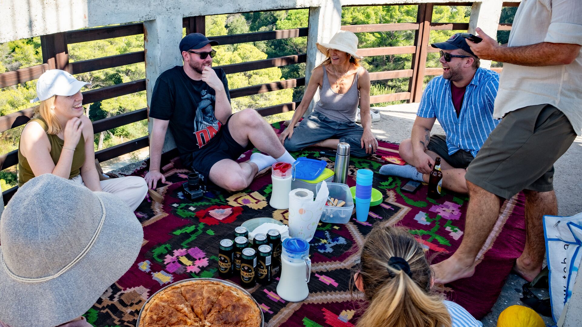 A group of travellers eating byrek on a birdwatching tower in Karavasta, Albania