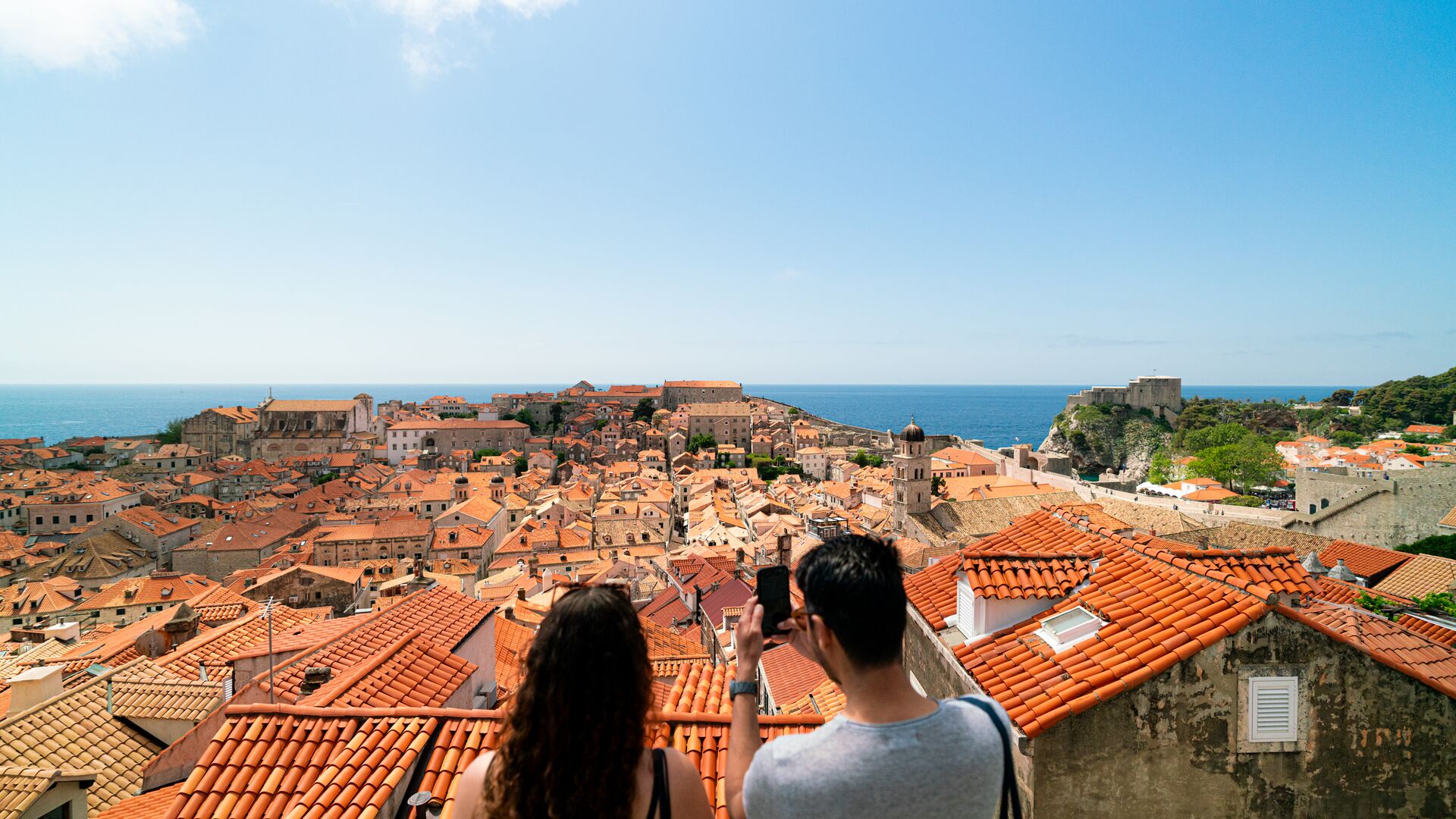 Two travellers take a photo overlooking the Old City of Dubrovnik