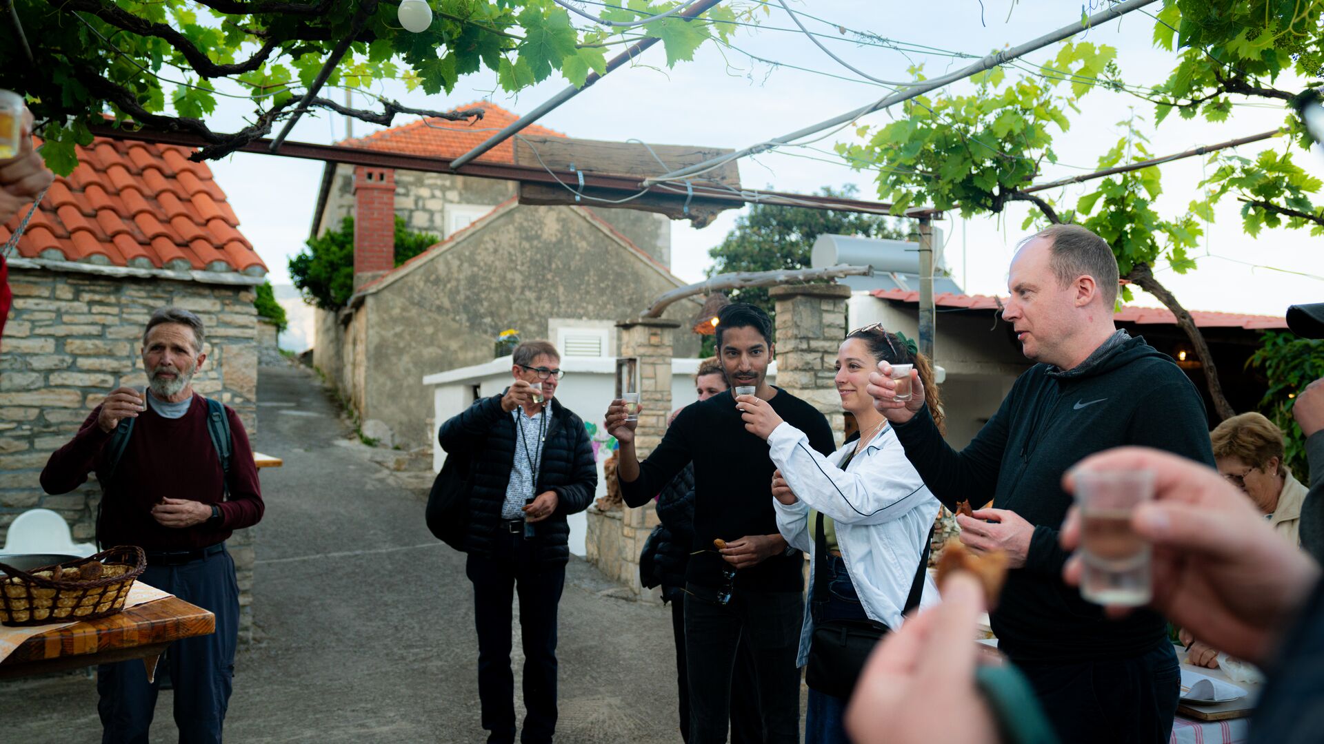 A group of travellers raising their glasses in a backyard