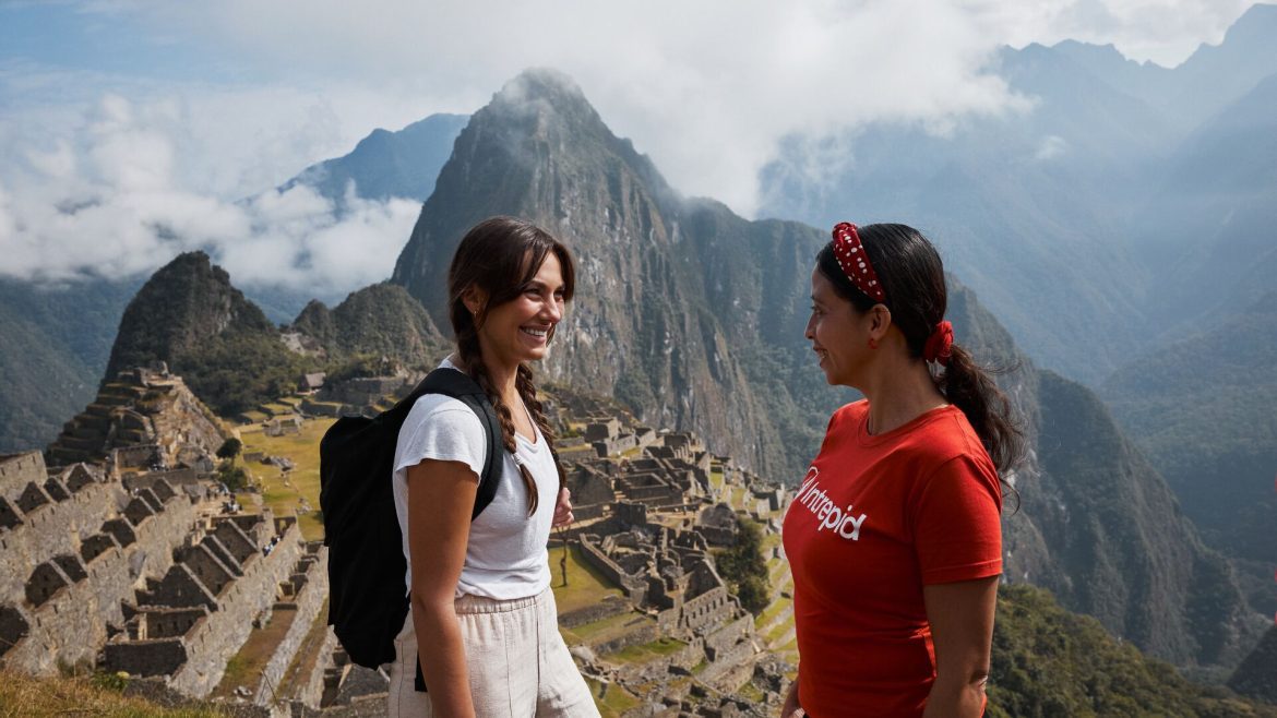 A traveller and Intrepid leader walking along a viewpoint at Machu Picchu