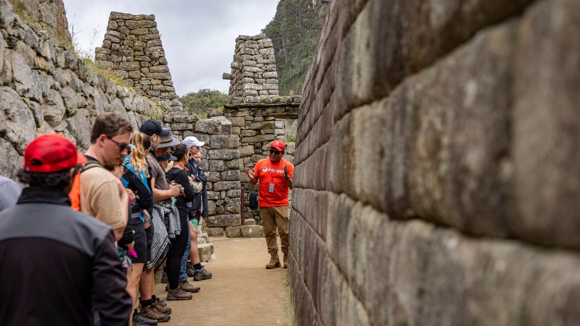 A group of Intrepid travellers observing the Incas' impressive stonemasonary at Machu Picchu