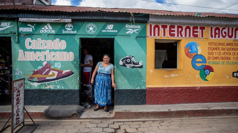 A woman stands outside her shop in Guatemala