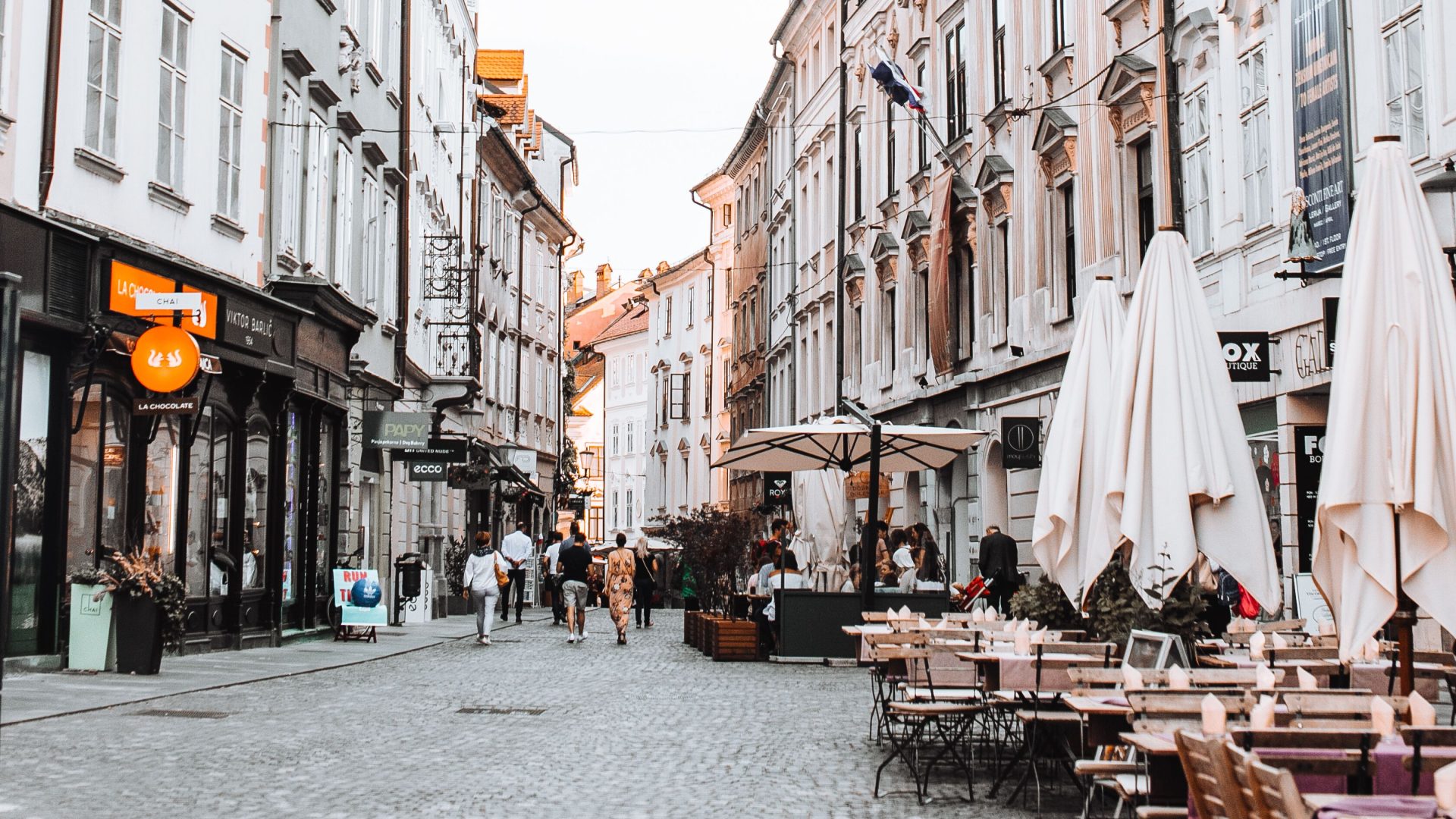 People walking down a restaurant-lined street in Ljubljana