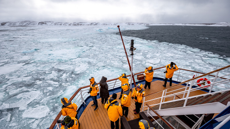 Passengers searching for wildlife from the back of the ship