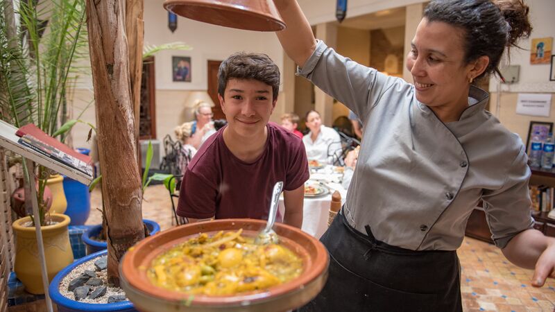 A female chef teaches travellers how to make a classic tagine.