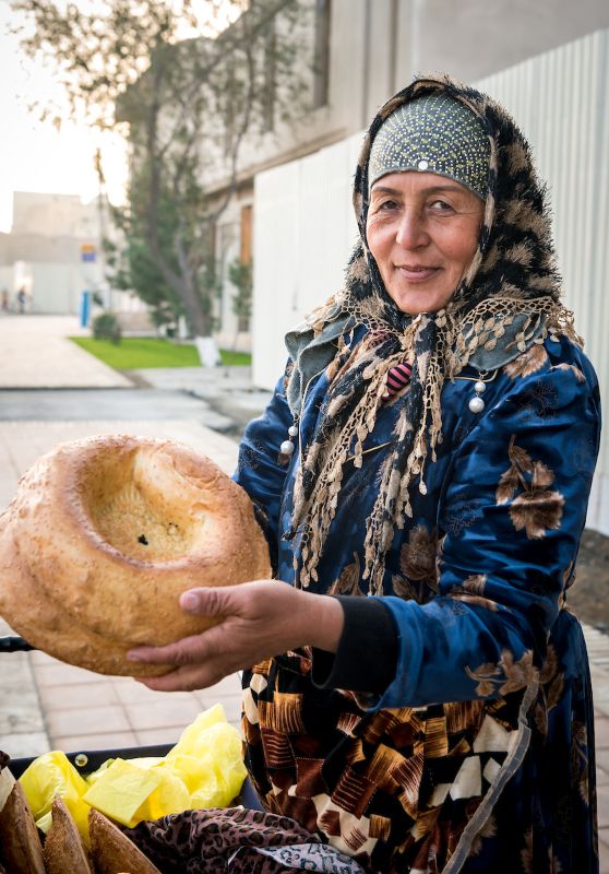 Uzbek woman holding traditional bread.