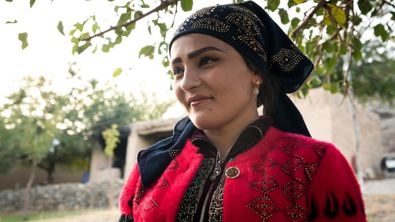 A newlywed woman in an Uzbek village smiles for the camera.