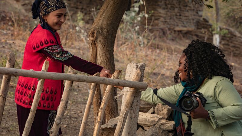 Photographer Lola shakes hands with a local woman
