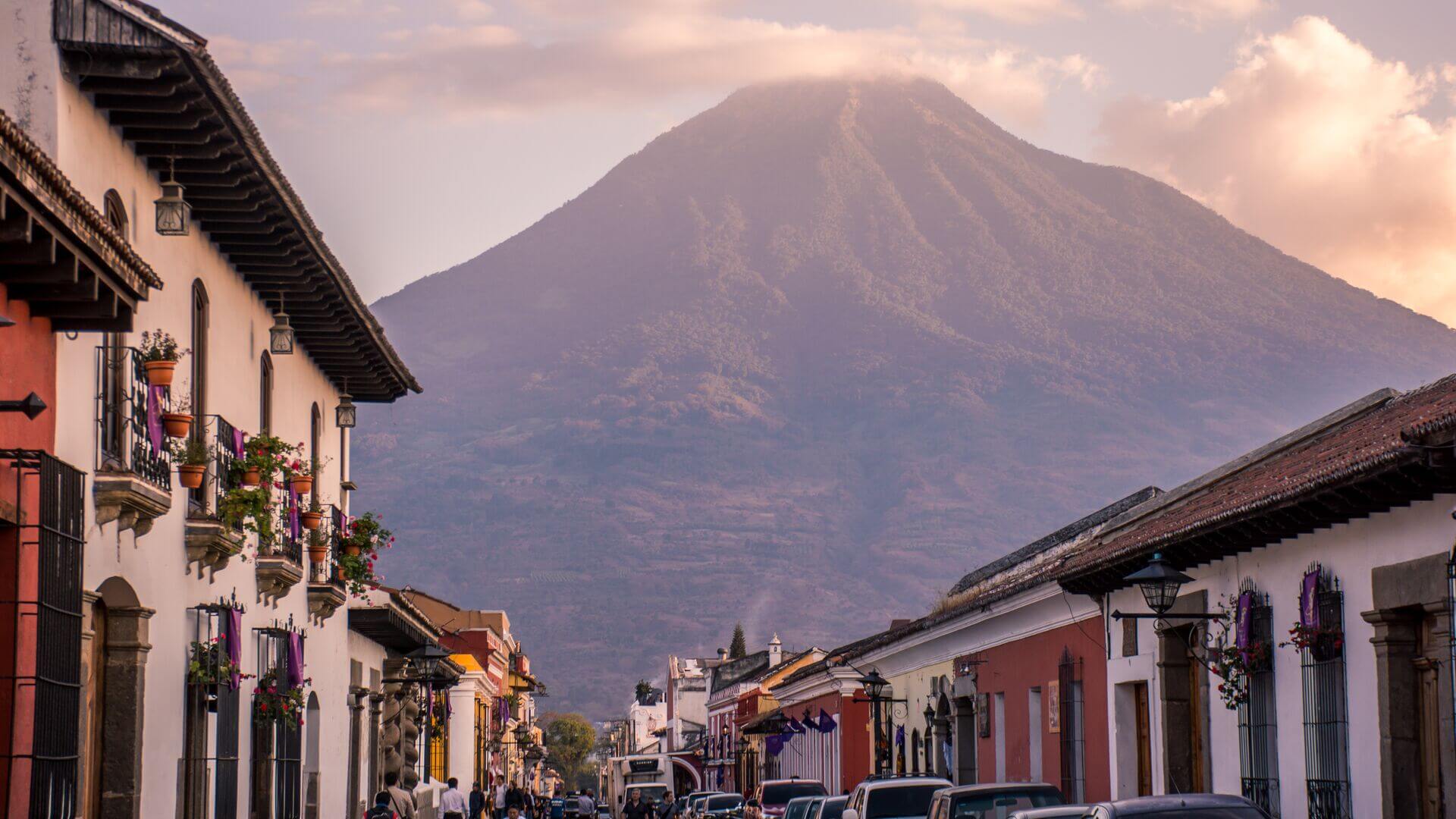 A volcano towers over a street in Antigua, Guatemala