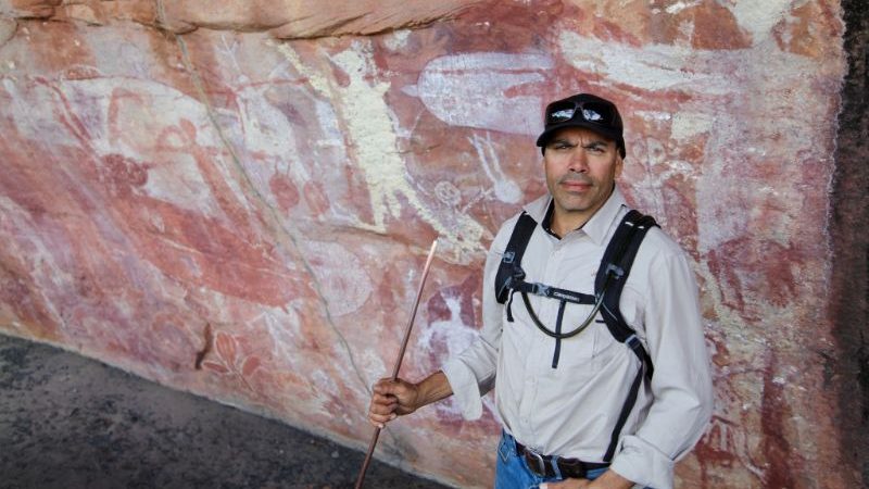 Aboriginal guide in front of rock art