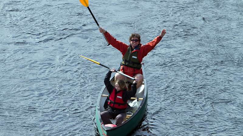 Father and daughter canoeing on Caledonian Canal in Scotland