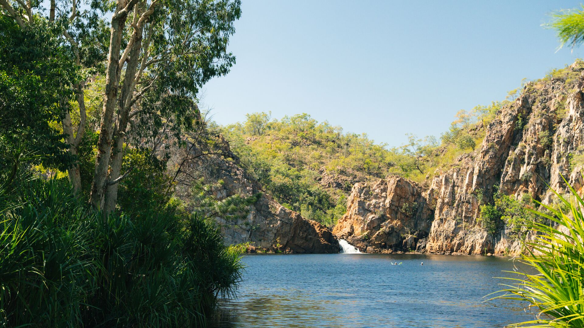 A watering hole in Nitmiluk with two swimmers.