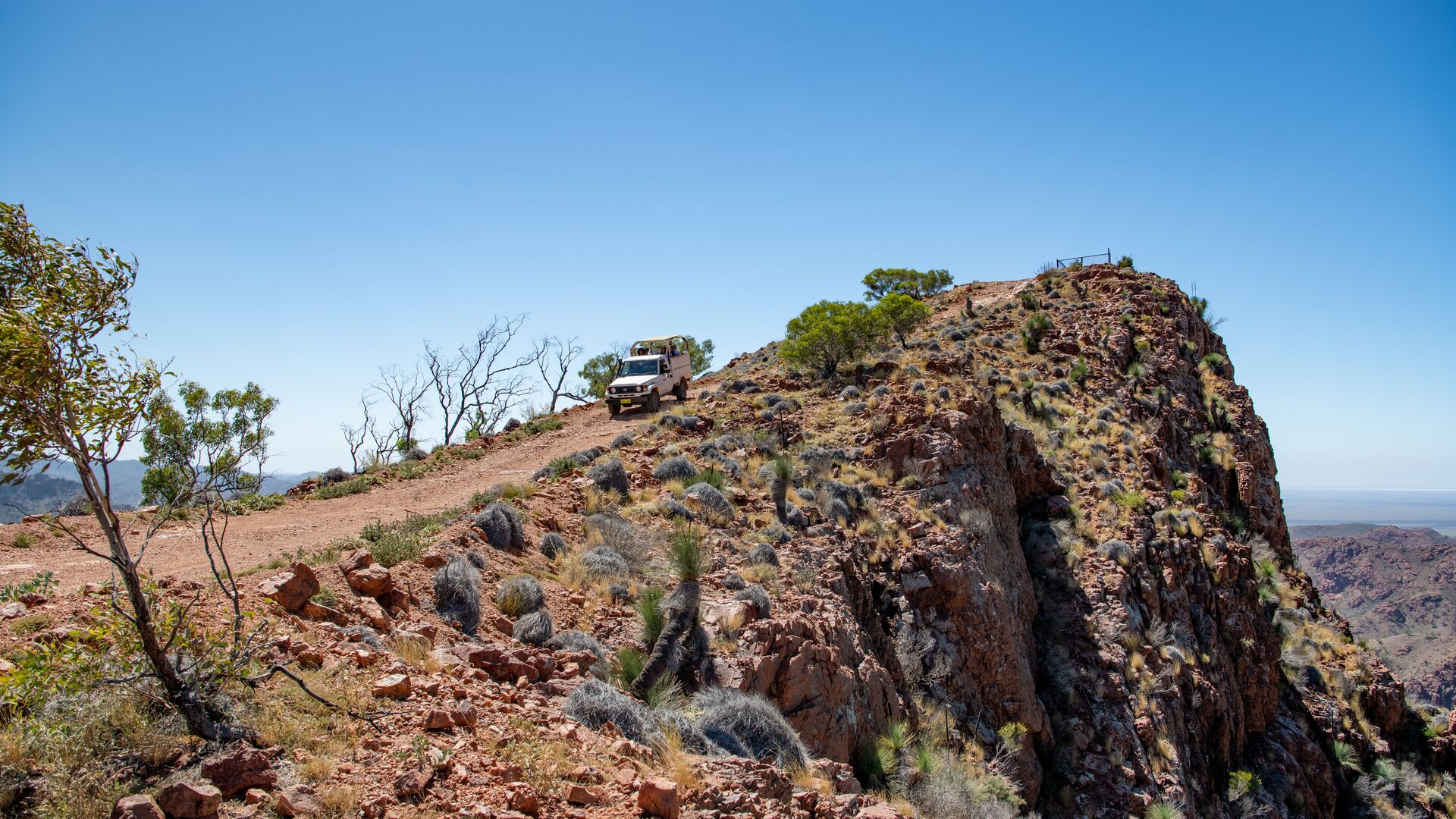 A 4WD is parked near the top of a cliff.