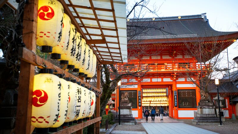 A beautiful red temple, with lanterns out the front, in Japan