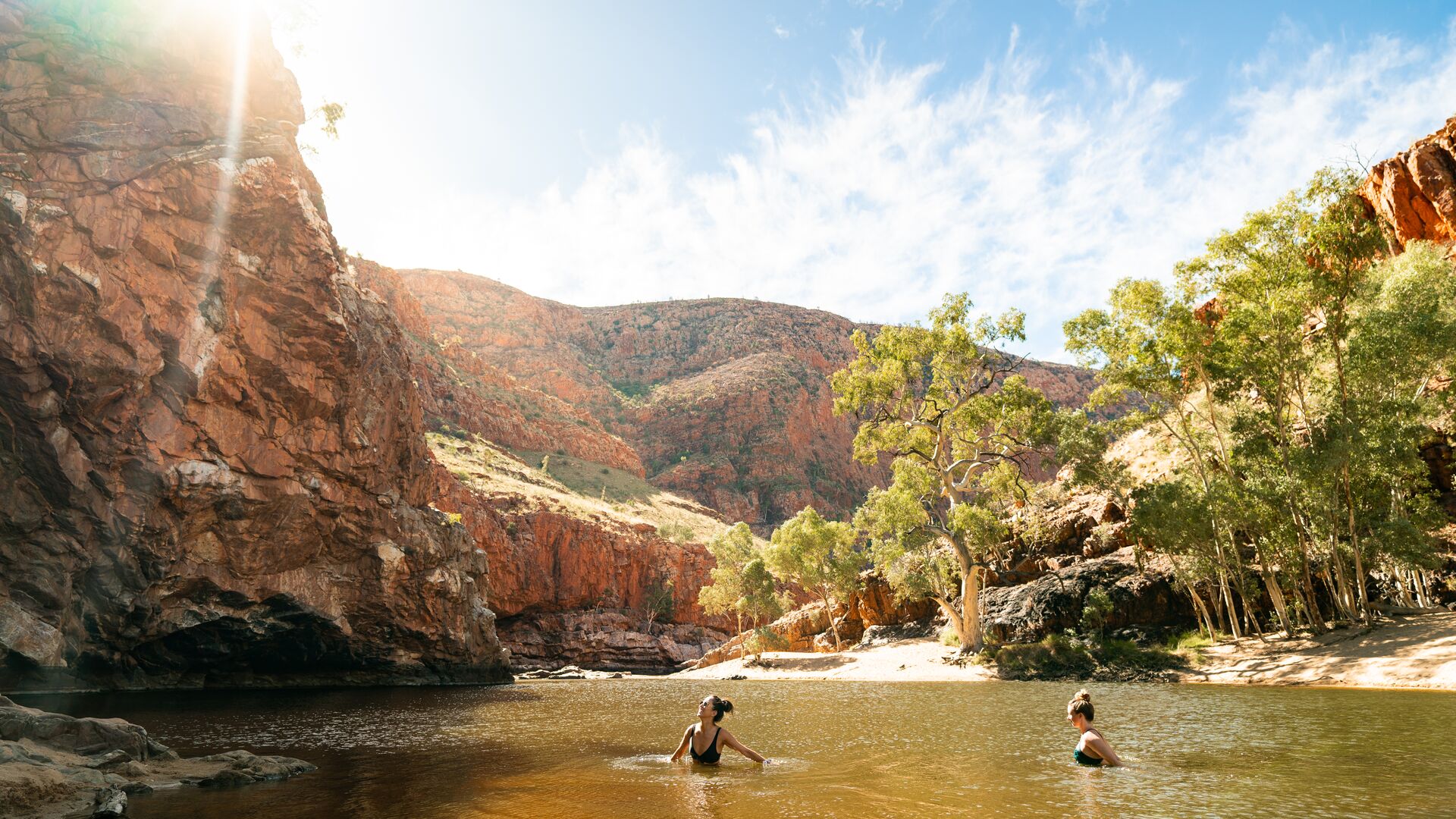 Two travellers swim in the waters of Ormiston Gorge in the Australian Outback.