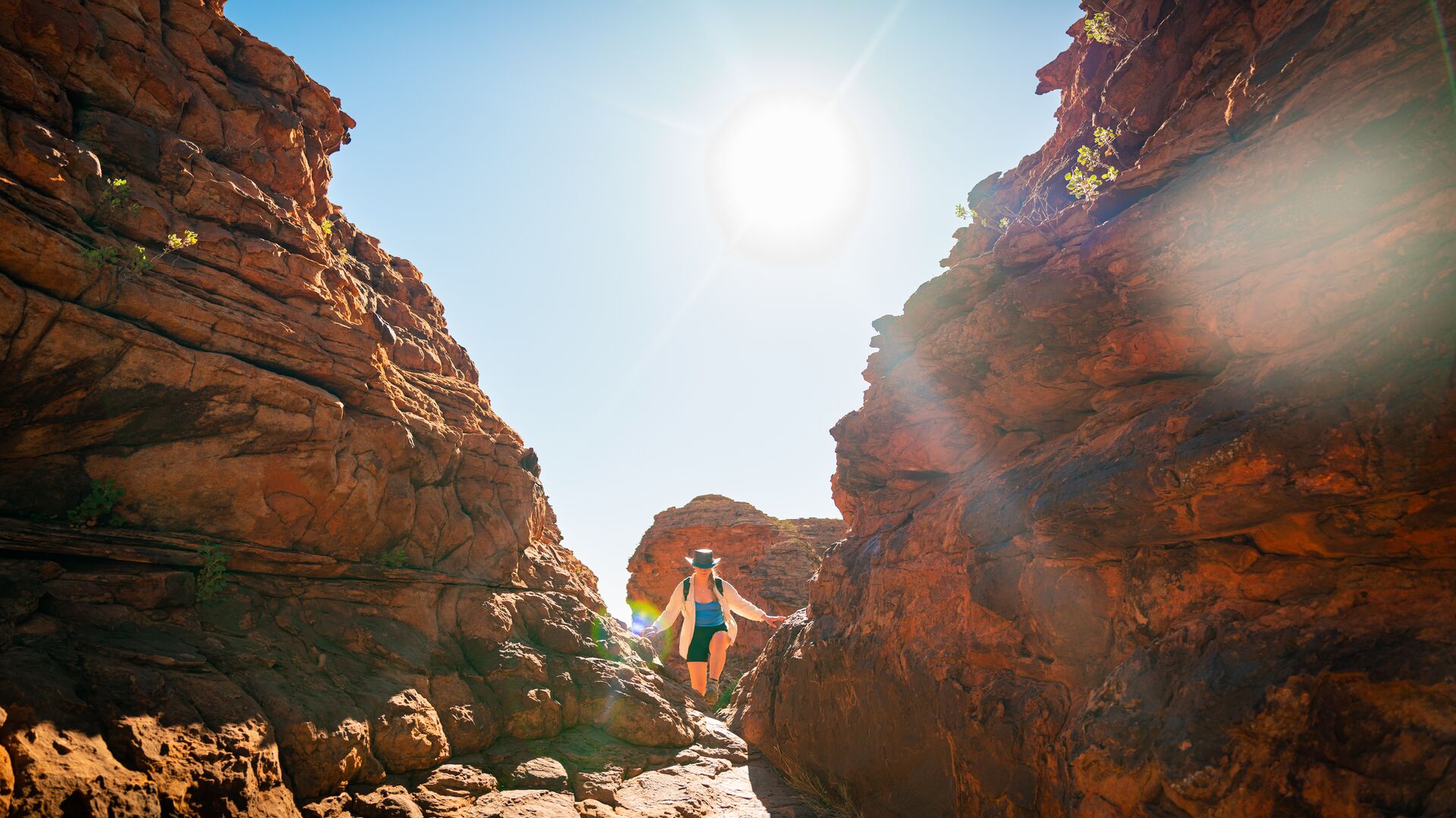 A traveller climbing through Priscilla's Crack on the Kings Canyon Rim Walk