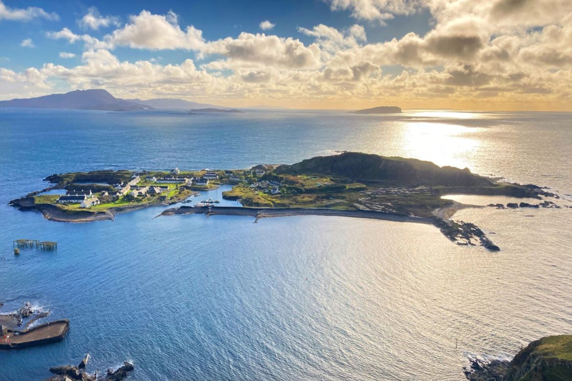 a small island with the sunsetting in the horizon