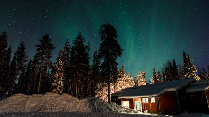The northern lights glow in shades of green above a house in Yllas, Finland.