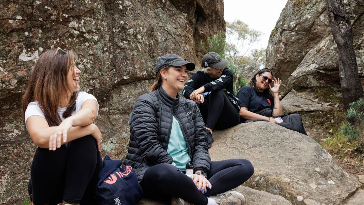 Rachael sits at Hanging Rock with fellow travellers.
