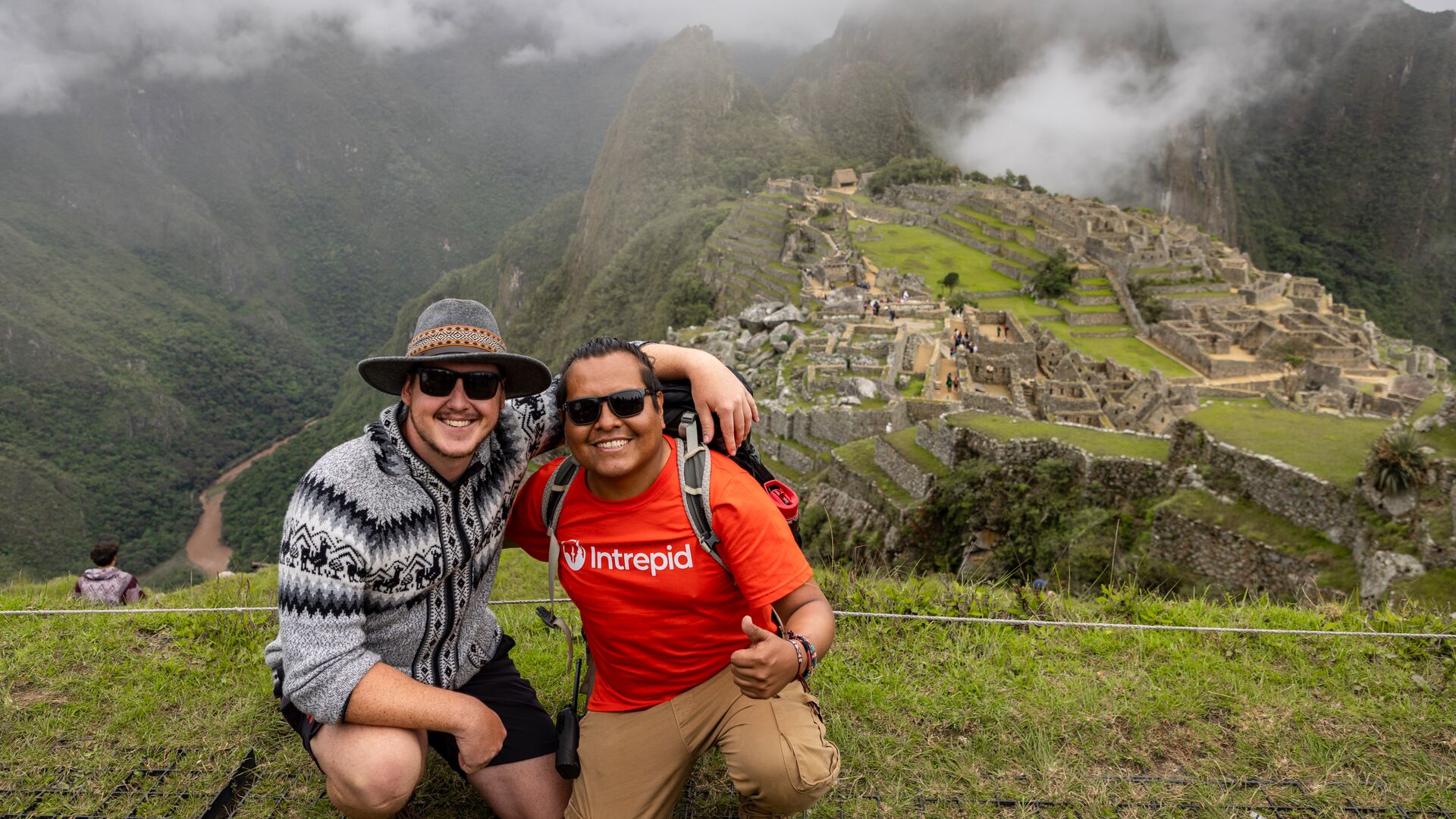 An Intrepid leader and a traveller pose for the camera, backdropped by Machu Picchu