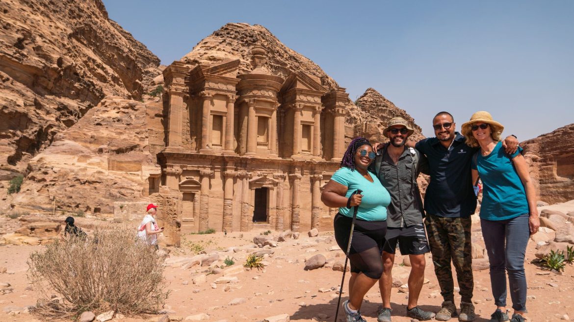 A group of travellers posing for a photo outside one of the ancient ruins of Petra