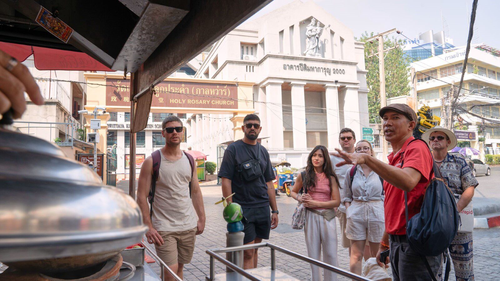 An Urban Adventures leader and group choosing what they're going to eat from a street food stall