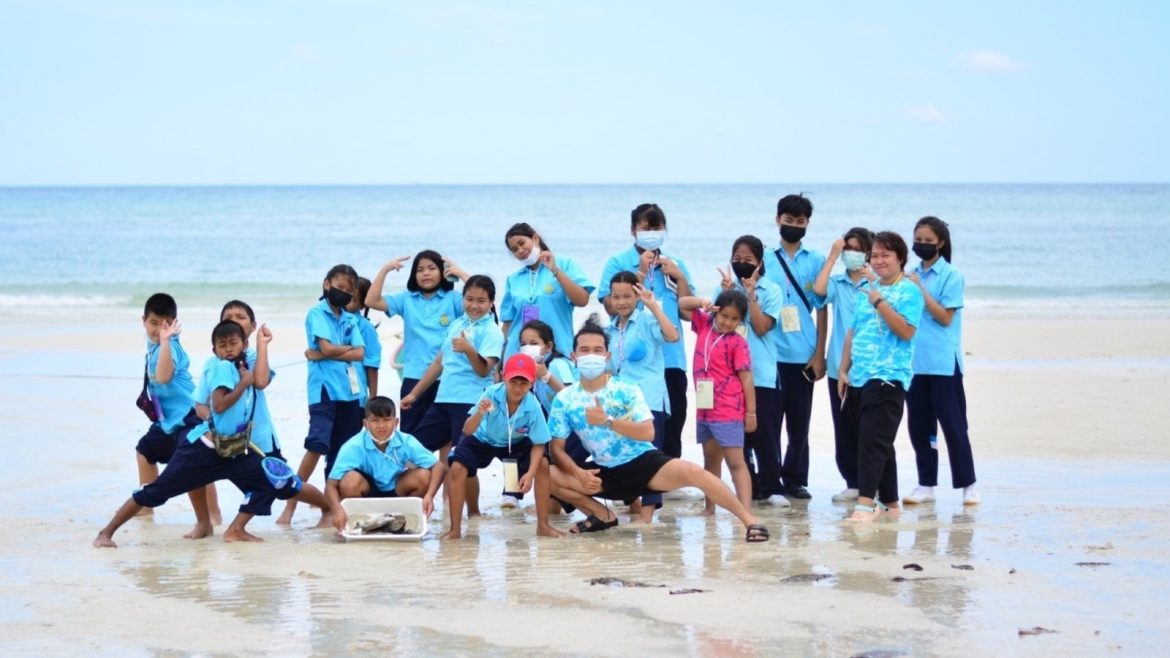 A group of kids and their teacher on a Thai beach