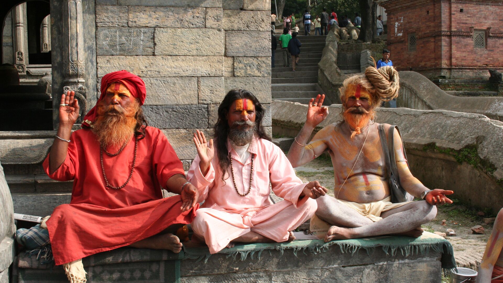 Three holy men (sadhus) sit cross-legged in Kathmandu, Nepal