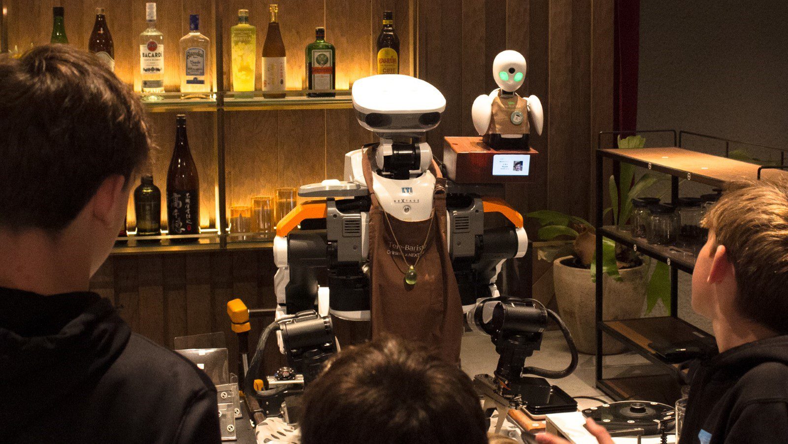A barista robot entertaining some children.