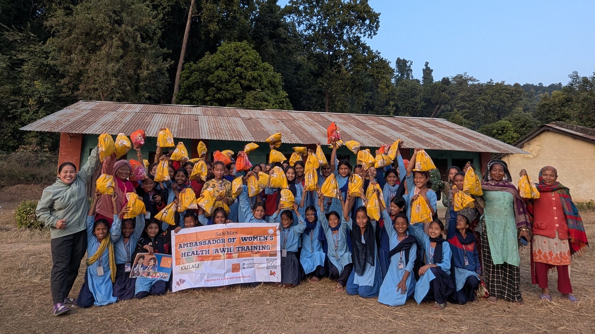 A group of women in Nepal smile with their new period kits