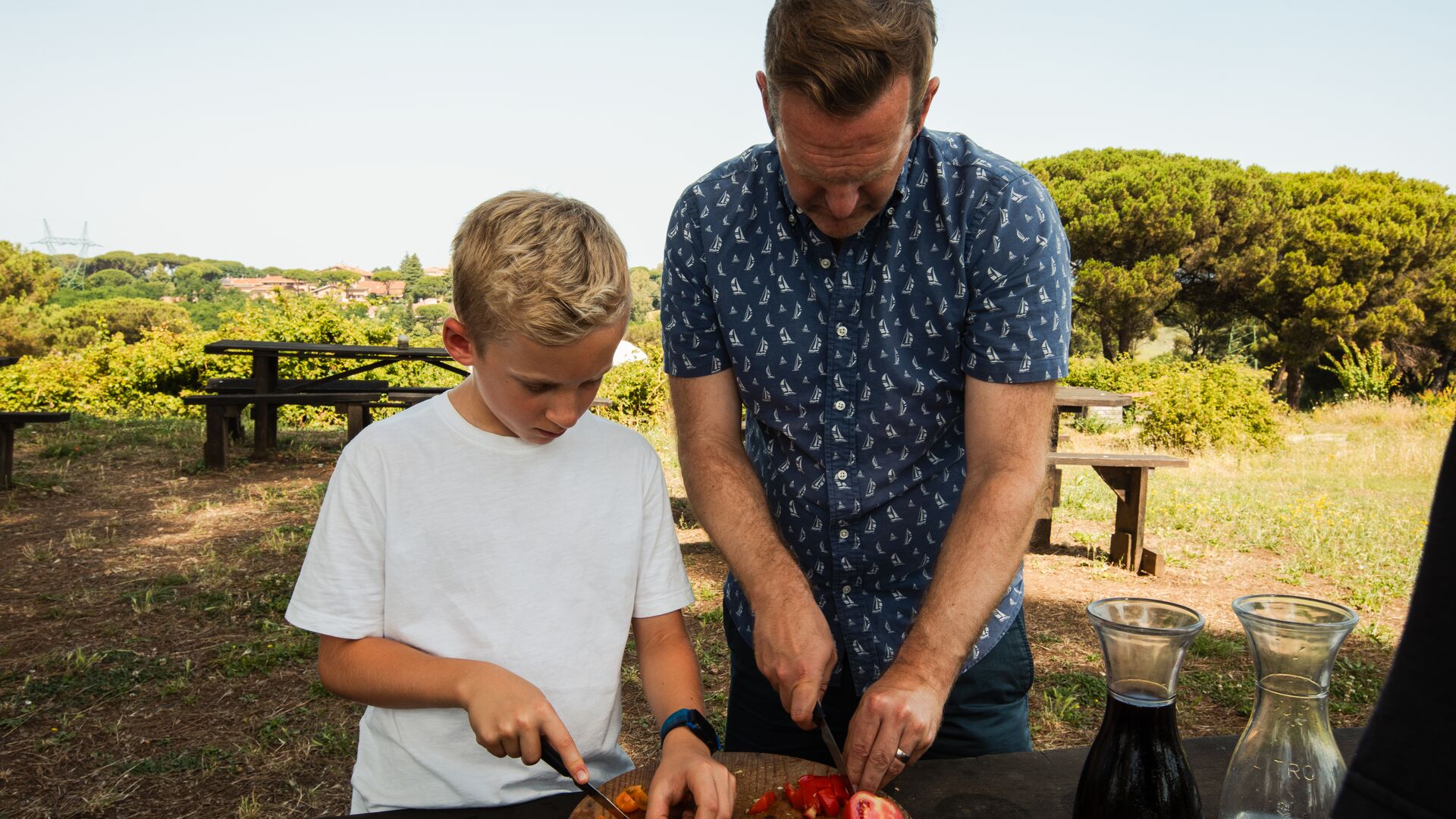 Father and son chop tomatoes outside at Cooperativa Corragio on the outskirts of Rome