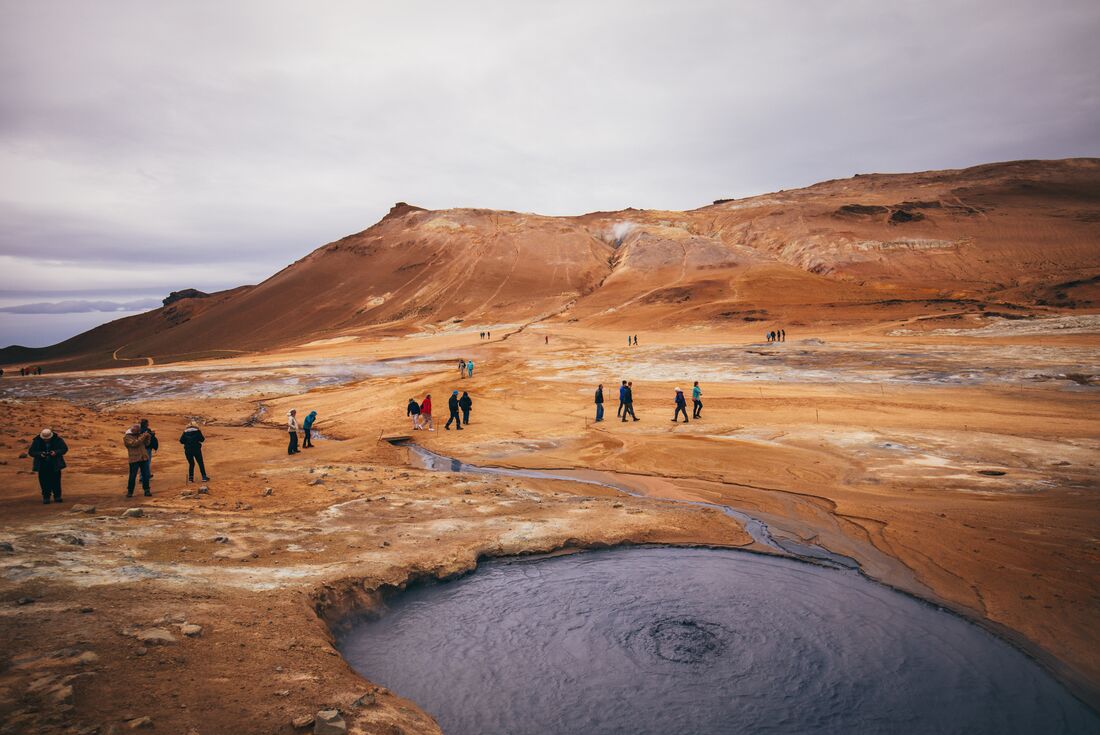 Travellers walk around the alien landscape of Hverir mud pits in northwestern Iceland