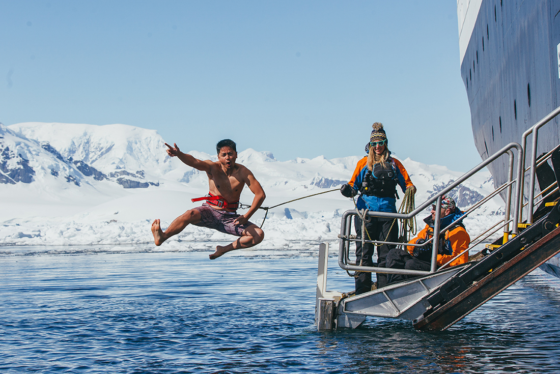 Traveller strikes a dramatic pose while undertaking the plunge into Antarctic waters