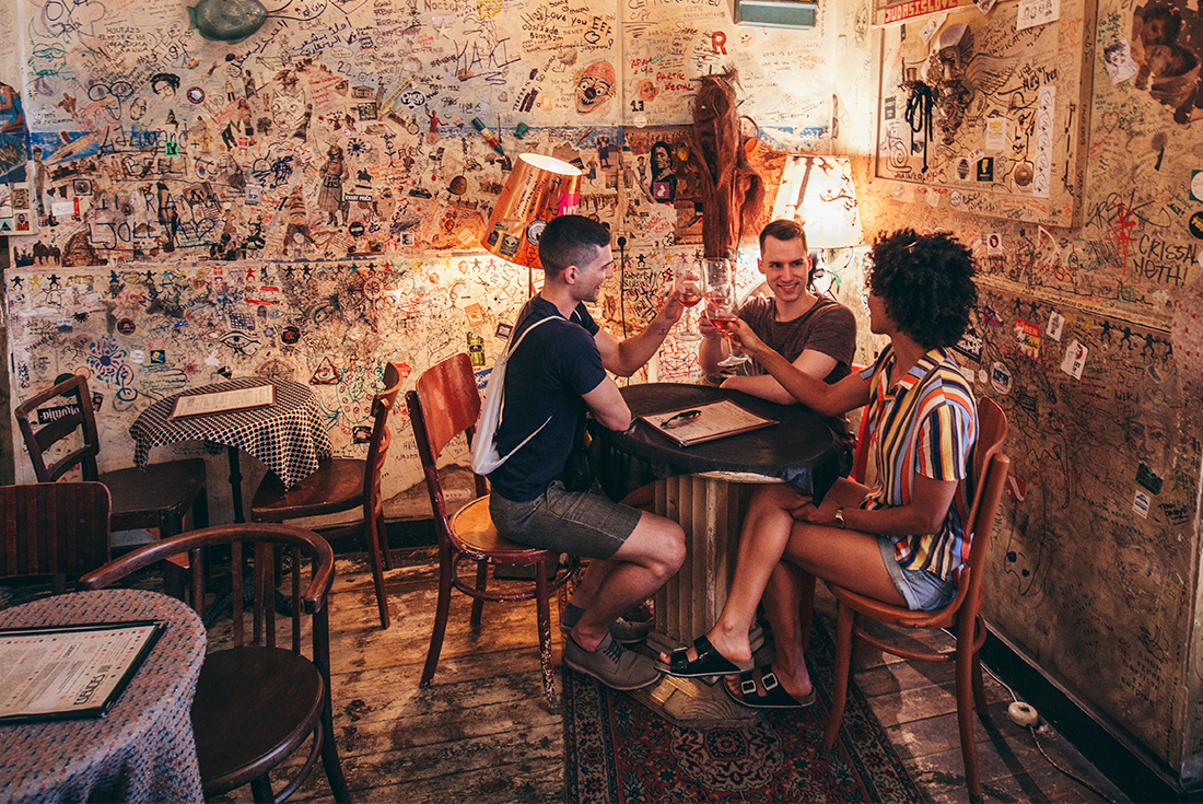 Table of travellers cheers in a colourfully decorated