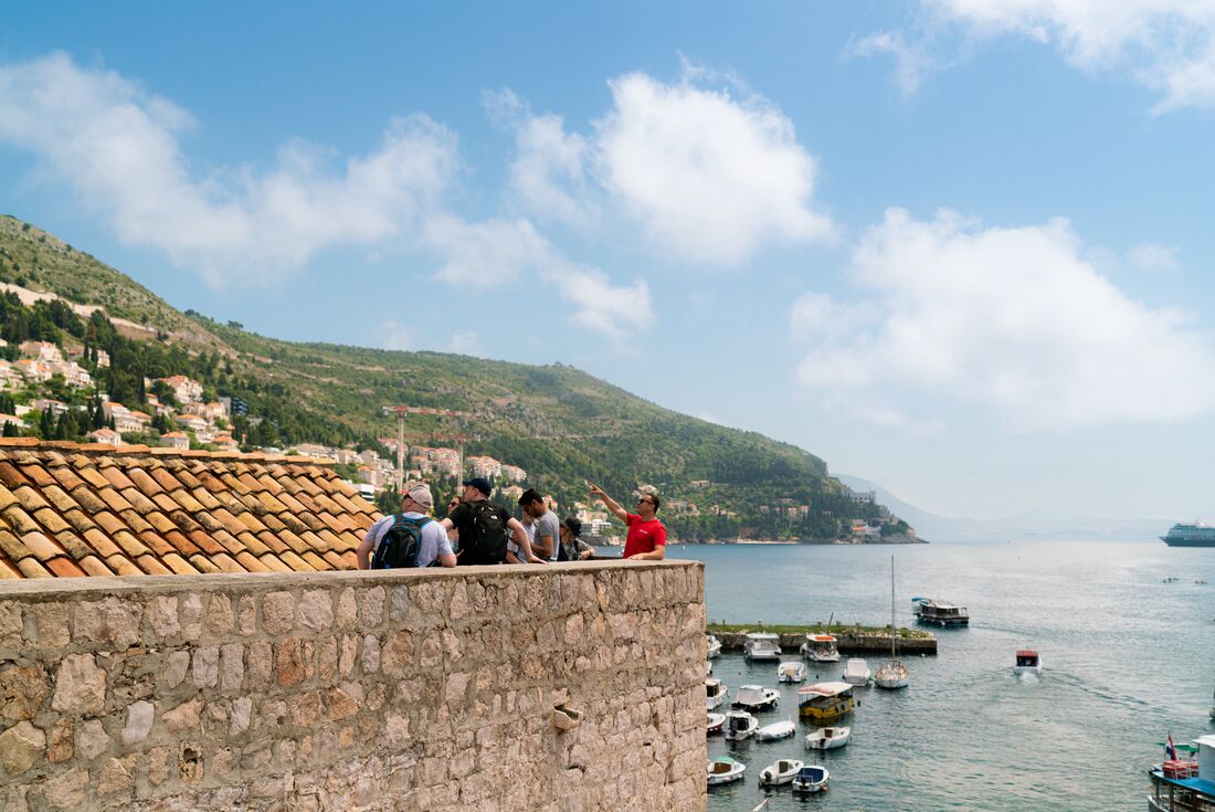 Intrepid leader points out features while walking Dubrovnik's ancient fortified city walls in Croatia 