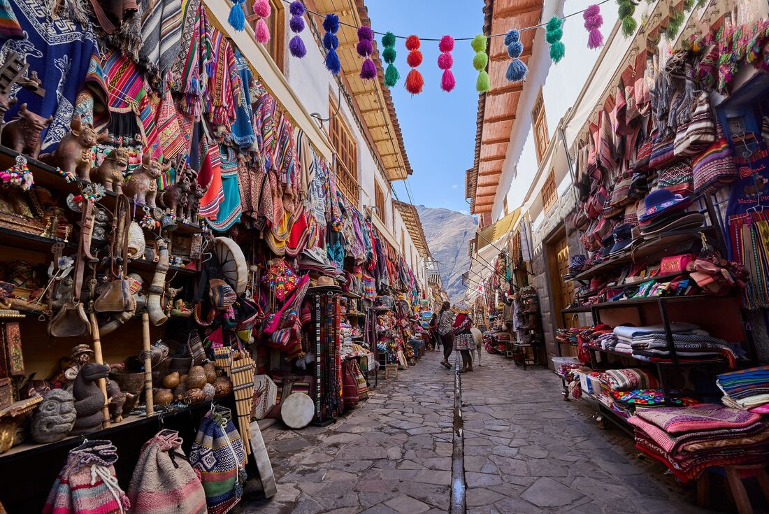 Colourful local crafted goods in Pisac's market in an acient cobbled Peruvian alleway