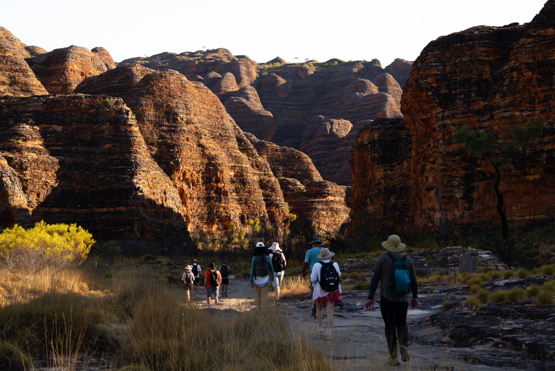 Intrepid travellers walking into the domes of the Bungle Bungle Range in Western Australia