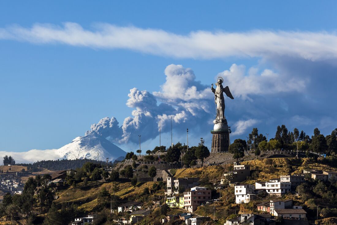 Panecillo's Madonna statue in Quito with Cotopaxi Volcano erupting in the background, Ecuador