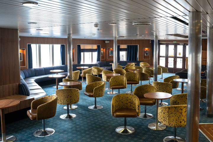 Aurora Lounge interior with lounge seating around small circular tables