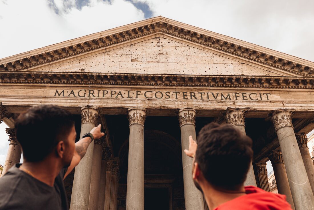 Two travellers looking up at the inscription on the front of the Pantheon, Rome, Italy