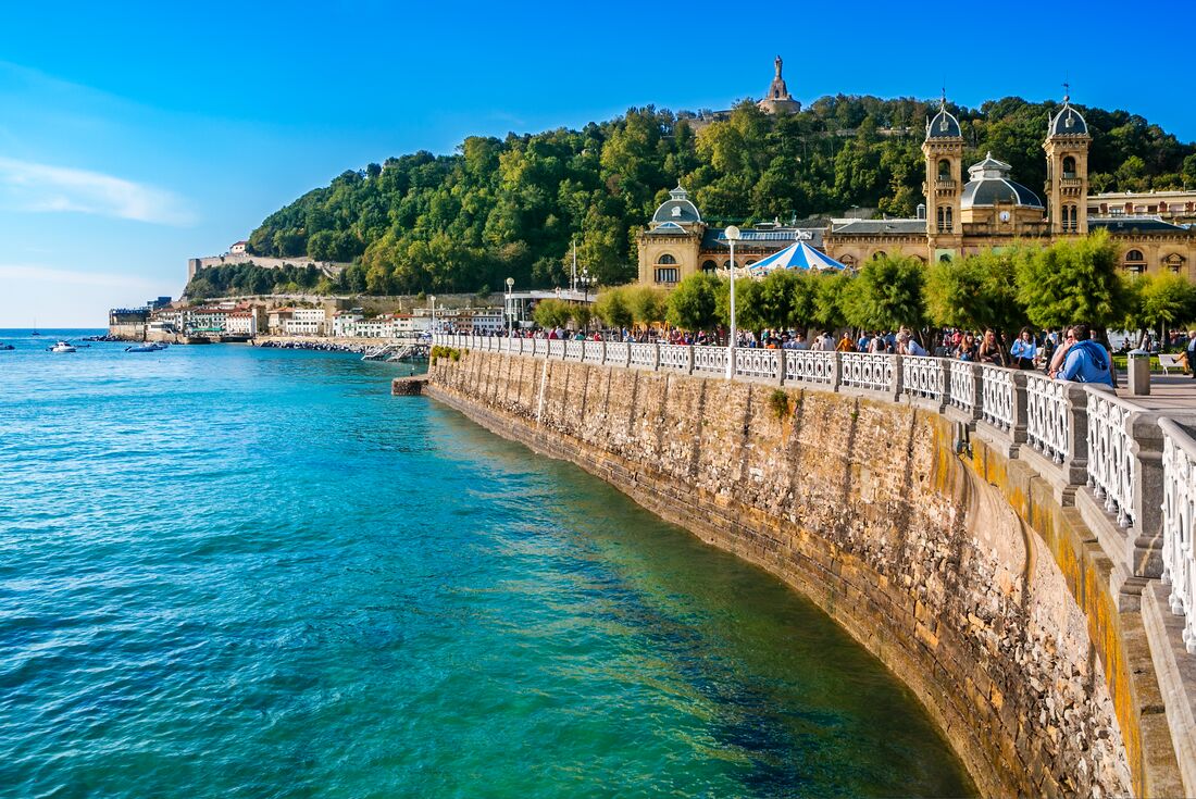Travellers and locals mingle on the walk along the coast at La Concha Bay in San Sebastian