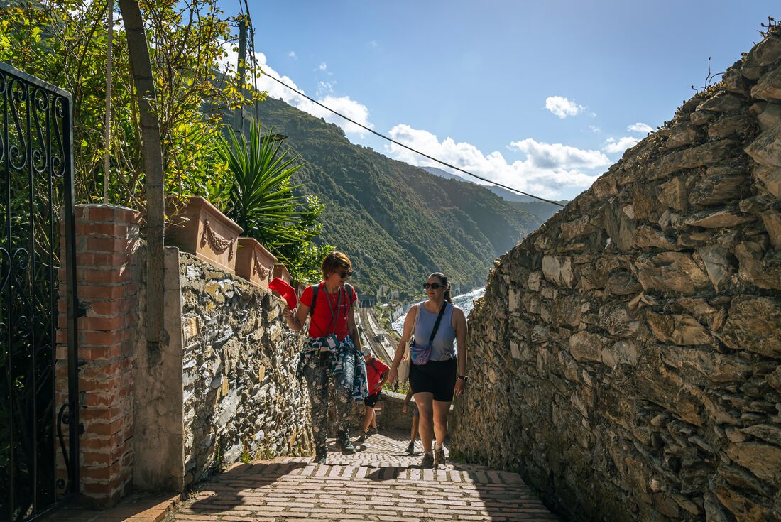 Leader and traveller smiling as they hike in Cinque Terre, Italy