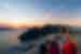 Intrepid travellers and leader look out at sunset over the Aegean Sea from a Santorini balcony