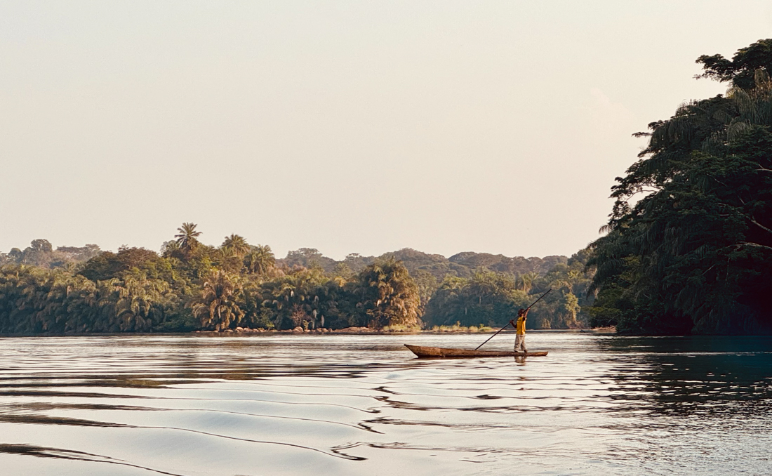 Locals out with a punting canoe ride on the Moa river near Tiwai Island in Sierra Leone