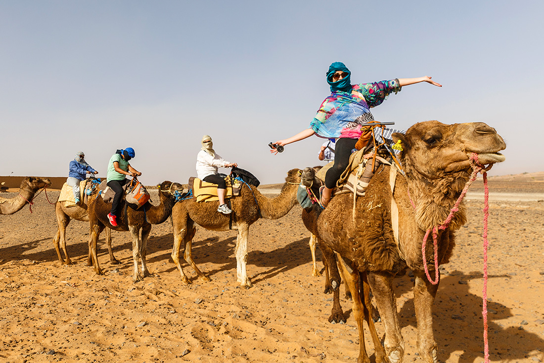 Travellers riding camels in Sahara Desert, Morocco