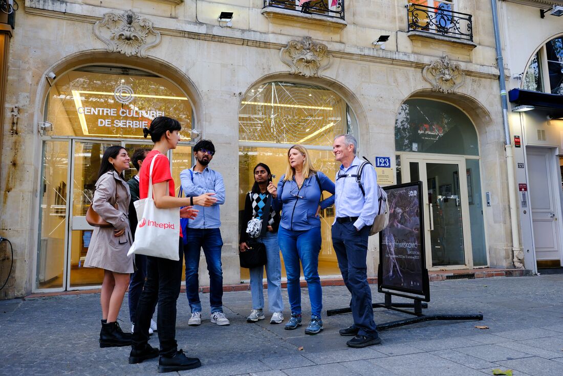 Group congregating out the front of a local store during a bites and sites tour in Paris France